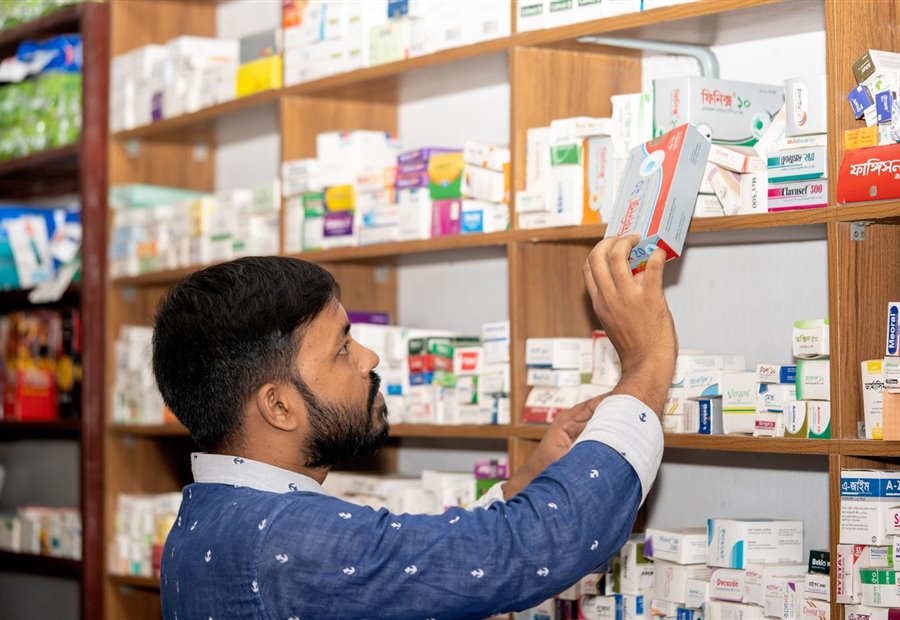 Droguerista surtiendo la estantería de su punto de venta
